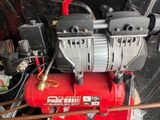 an image of a red air compressor sitting on top of a table