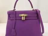un sac à main violet posé sur une table blanche