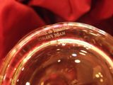 a close up of a glass of wine with a red cloth in the background