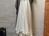 a white dress hanging on a clothes rack in a room