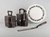 une assiette blanche ornée d'un motif en noir et blanc, à côté d'un ensemble d'outils et d'une assiette blanche ornée d'un motif en noir et blanc