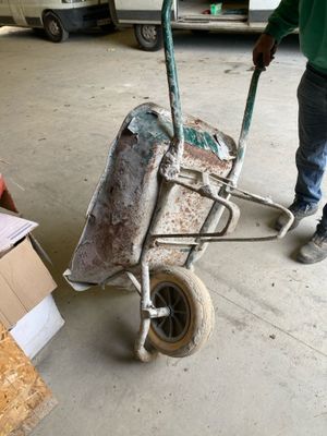 a man pushing a wheelbarrow in a garage