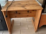 a wooden table with a drawer on it in front of a door