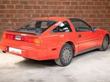 a red car parked in a garage next to a brick wall