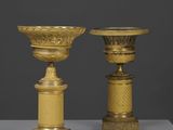 deux vases en or posés l'un à côté de l'autre sur une table