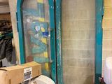 two large green doors in a room with a lot of stuff