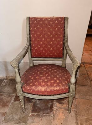 une chaise dont l'assise est recouverte d'un tissu rouge