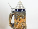 a blue and gold beer mug with a spoon in it