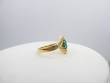 an image of a gold ring with a green stone