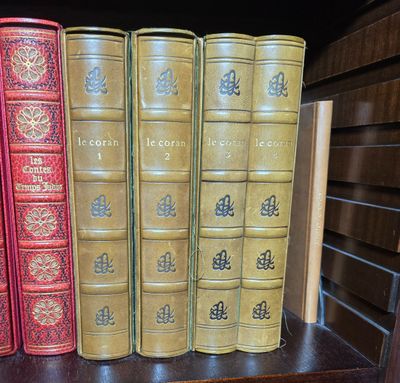 quatre livres posés sur une étagère d'une bibliothèque