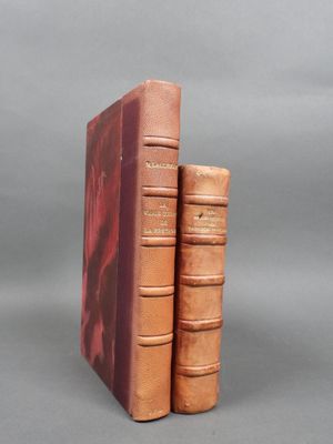 two brown books sitting on top of each other on a gray surface