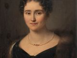 portrait d'une femme en robe noire portant un collier de perles