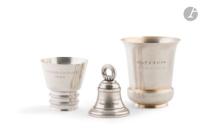 deux coupes en argent et une clochette en argent sur fond blanc