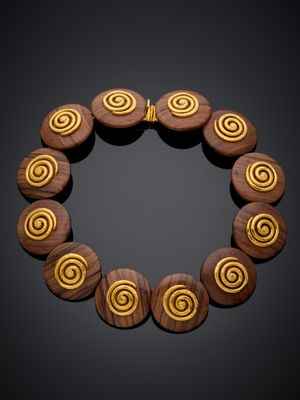 un gros plan d'un bracelet en bois orné de motifs en spirale