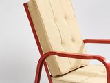 a red chair with a beige cushion on it