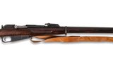 un fusil avec un canon en bois sur fond blanc