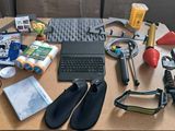 un bureau sur lequel se trouvent un ordinateur portable, un clavier, une souris, un casque et d'autres objets