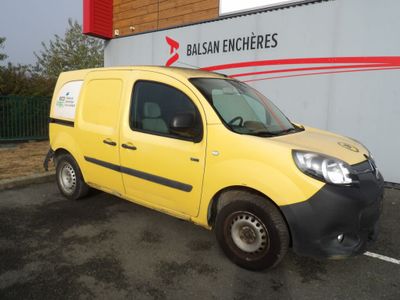 La petite camionnette jaune est garée devant un immeuble.