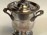 a silver vase with a lion head on it