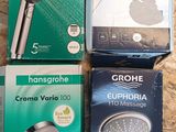 trois pommeaux de douche Grohe dans leur emballage, posés sur une surface en bois