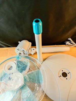 une photo d'une table sur laquelle se trouvent un ventilateur et d'autres objets