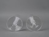 two empty wine glasses sitting on top of each other on a table