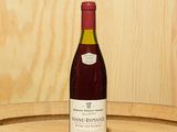 une bouteille de vin posée sur un tonneau