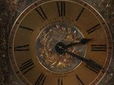 a gold clock with roman numerals on the face of it