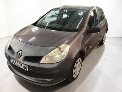 La voiture grise est garée dans une pièce blanche au sol blanc.