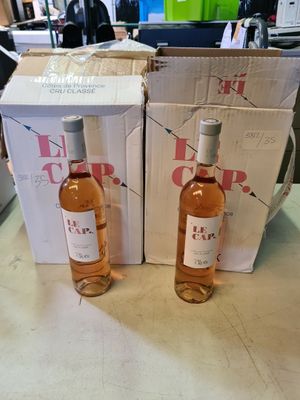 deux bouteilles de vin posées sur une table, à côté d'une boîte