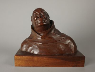 statue d'un homme assis sur un socle en bois, sur fond blanc