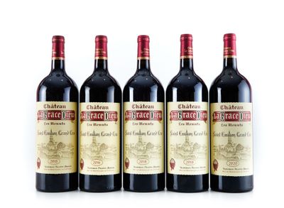 quatre bouteilles de vin sont alignées sur une surface blanche