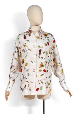 une photo d'un mannequin portant une chemise blanche ornée de fleurs colorées