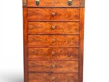 an antique chest of drawers with a wooden top and brass handles