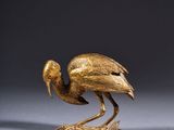 bronze sculpture of a bird on a rock