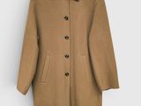 Ce manteau est en laine et possède un col boutonné.