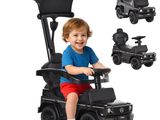 un petit garçon assis sur une voiturette de golf jouet noire