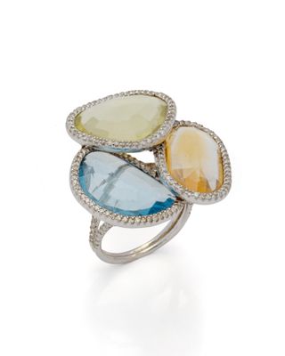 un gros plan d'une bague ornée de trois pierres de couleurs différentes