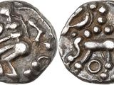 a silver coin with an image of a man and a dog on it