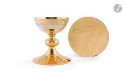 un calice en or à côté d'une pièce d'or