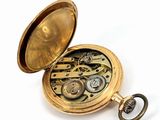 a gold pocket watch with gears inside of it