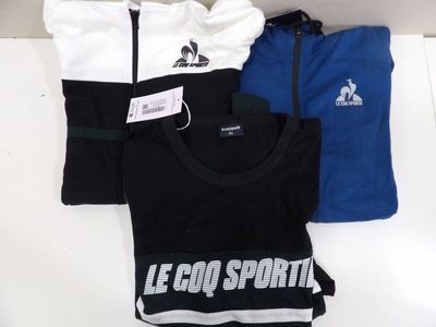 trois t-shirts portant l'inscription « Le Coq Sport » en blanc, bleu et noir