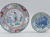 two plates with asian designs on them sitting next to each other
