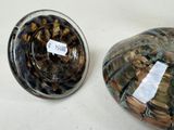 two vases sitting on a table with labels on them