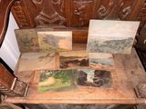 a wooden bench with a bunch of paintings on it