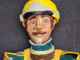 a figurine of a man wearing a helmet and a green jacket