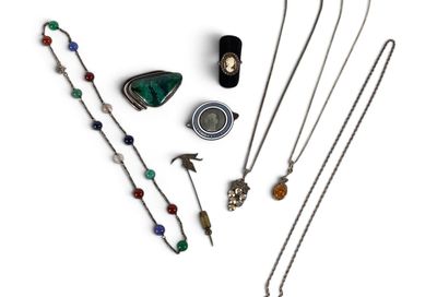 Divers colliers et pendentifs sont disposés sur une surface blanche