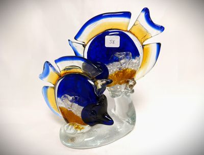 a glass figurine of a fish on a glass base
