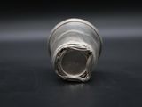 close up of a silver metal object on a black surface