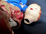 a doll that is laying on the ground next to a doll